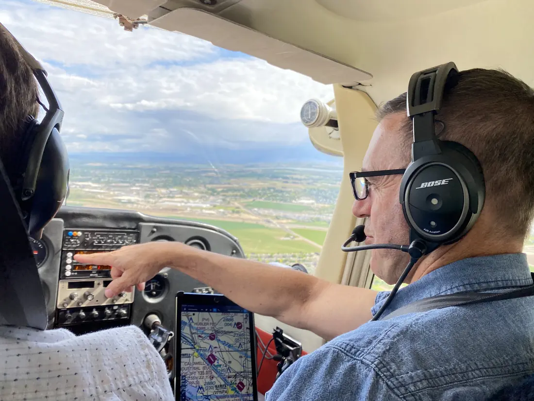 Flight instructor pointing out landmarks from the cockpit of a Cessna 172 over the Treasure Valley